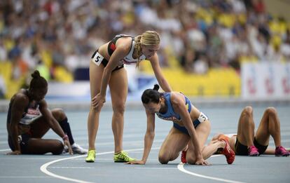 Ganna Melnichenko, de Ucrania (de rodillas), es felicitada por la canadiense Brianne Theisenis, que fue plata, tras ganar la prueba de heptatlón femenino. Melnichenko no ganó ninguna de las siete pruebas, pero se hizo con el oro tras obtener grandes resultados tanto en carreras como en lanzamientos.