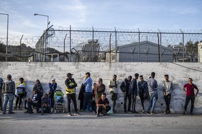 Pessoas de muitos países do Oriente Médio e da África vivem no campo de refugiados. Na foto, alguns deles esperam o ônibus que vai para Mitilene, a capital da ilha de Lesbos.