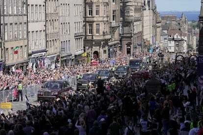Centenares de personas se han congregado en la Royal Mile, en el centro de Edimburgo, en la que ha tenido lugar la llamada 'Royal Procession'. En la imagen, el paso de los coches que llevaba a los reyes y los príncipes de Gales a la catedral de St Giles.
