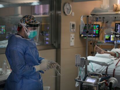 Un sanitario atiende a un paciente en la UCI del Hospital Vall d'Hebron de Barcelona.