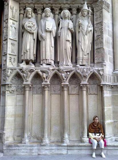 Una turista descansa en compañía de los santos de la Catedral de Notre Dame, en París. "No estoy seguro si las figuras de piedra miran a la mujer con una mueca de aprobación o todo lo contrario", medita Mullan.