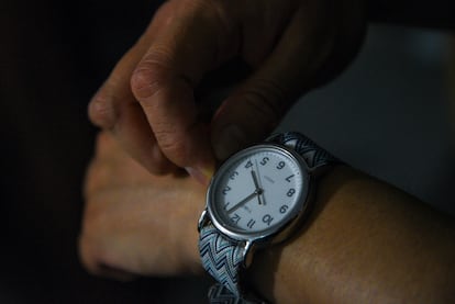 Una persona ajusta su reloj, en una ilustración fotográfica.