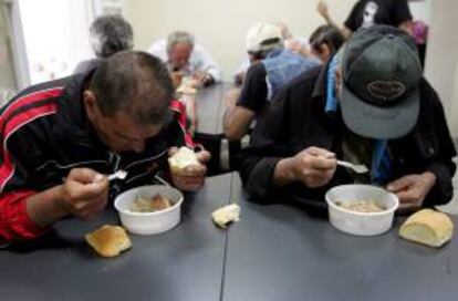 Dos hombres de pocos recursos reciben comida gratis en una iniciativa de distribucin municipal en Atenas (Grecia). EFE/Archivo