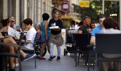 Una joven camarera atiende una terraza en la zona centro de Madrid.