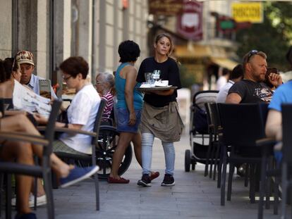 Una joven camarera atiende una terraza en la zona centro de Madrid.