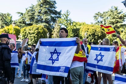 Manifestantes sujetan banderas de Israel, este domingo en la plaza de Cibeles. 