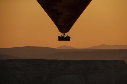 Un globo aerostático, que transporta turistas, se eleva hacia el cielo al amanecer en Capadocia, en el centro de Turquía.