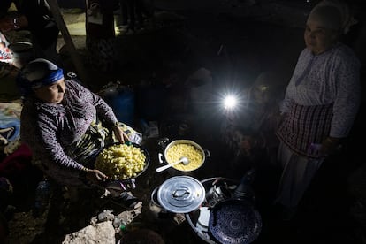 Unas mujeres preparan perolos de pasta para dar de comer a vecinos del pueblo que, como ellas, dormirán al raso. Parte de esta comida procede de donaciones que se han canalizado a través de la ONG local 'Encuentro'.  