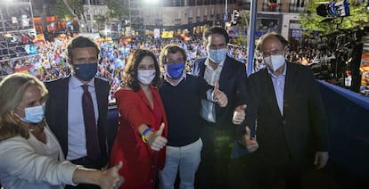 El líder del PP, Pablo Casado; la presidenta de la Comunidad de Madrid y candidata a la reelección por el PP, Isabel Díaz Ayuso; el alcalde de Madrid, José Luis Martínez-Almeida; y otros miembros del partido salen al balcón para celebrar los primeros sondeos en la sede del partido durante la jornada electoral.