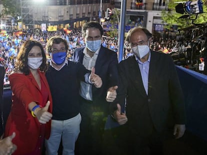 El líder del PP, Pablo Casado; la presidenta de la Comunidad de Madrid y candidata a la reelección por el PP, Isabel Díaz Ayuso; el alcalde de Madrid, José Luis Martínez-Almeida; y otros miembros del partido salen al balcón para celebrar los primeros sondeos en la sede del partido durante la jornada electoral.