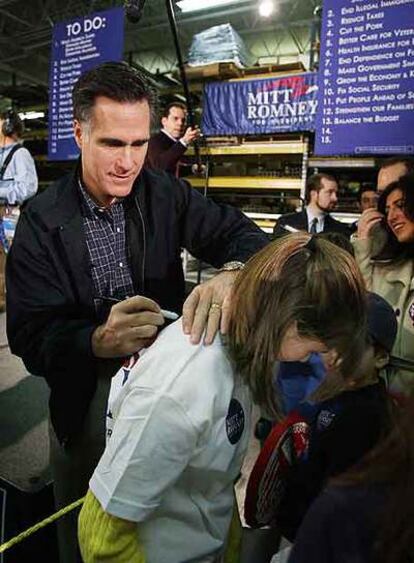 El candidato republicano y ex gobernador de Massachusetts Mitt Romney firma un autógrafo en Grand Rapids.