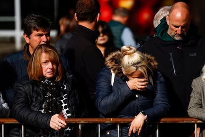 Varias personas muestran su tristeza tras el paso del cortejo fúnebre por la localidad de Ballater, Escocia. 