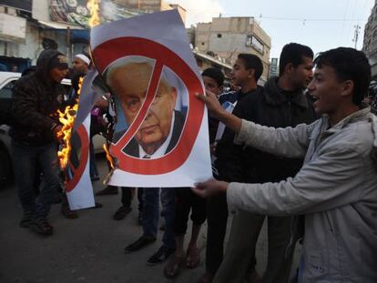 Unos palestinos queman fotos de Ariel Sharon en la franja de Gaza este sábado.