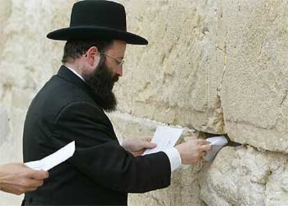 El rabino Samuel Rabinovich coloca mensajes a Dios en el Muro de las Lamentaciones ayer en Jerusalén.