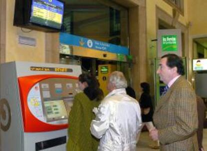 Viajeros compran sus billetes en las máquinas de la estación ferroviaria de Oviedo, Asturias. EFE/