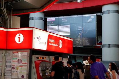 Unos viajeros sacan los billetes de tren en la estación de Atocha Cercanías.