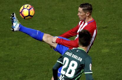 El delantero del Atlético de Madrid Fernando Torres (d) con el balón ante el defensa del Betis José Carlos Ramírez Suárez.