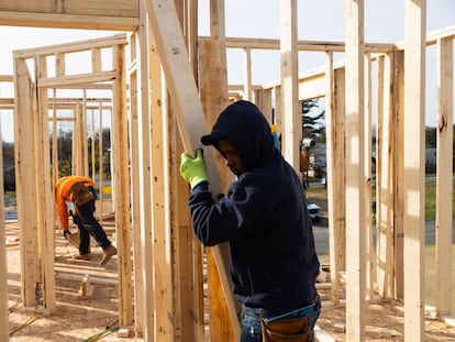 Un trabajador transporta madera en una casa en construcción en Loudonville, Nueva York, en noviembre de 2023.