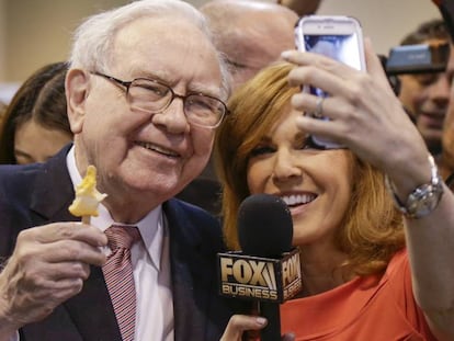 Warren Buffett posa para una foto con una periodista en la junta de Berkshire Hathaway.