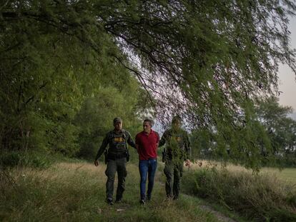 Dos agentes de seguridad fronterizos detienen a un inmigrante de Honduras en Mission, Texas (EE UU), el 13 de junio.