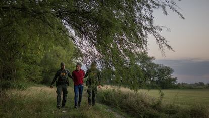 Dos agentes de seguridad fronterizos detienen a un inmigrante de Honduras en Mission, Texas (EE UU), el 13 de junio.