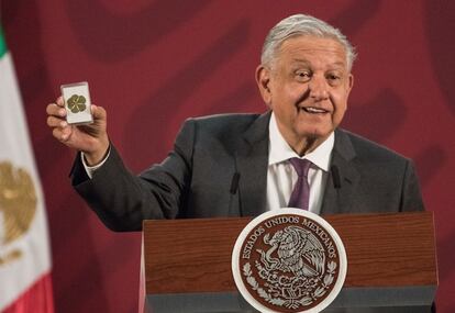 El presidente de México, Andrés Manuel López Obrador, muestra una estampita en la rueda de prensa matutina.