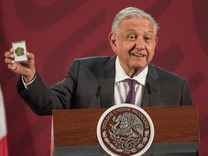 El presidente de México, Andrés Manuel López Obrador, muestra una estampita en la rueda de prensa matutina.