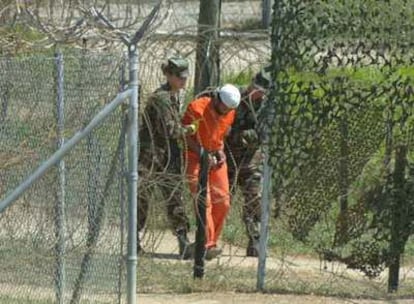 Un preso de Guantánamo es trasladado por dos soldados para someterle a un interrogatorio en 2002.