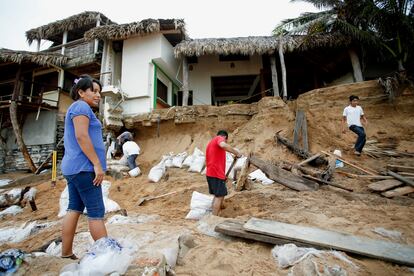 Residents of San Agustinillo begin cleaning the beach in the wake of Hurricane Erick.