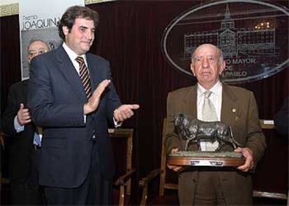 Victorino Martín recibe el galardón de manos de Joaquín Vidal, hijo del crítico fallecido.