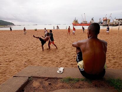 Em uma das praias de Itaboraí, um grupo de caminhoneiros e transportadores joga futebol. Ao fundo, os petroleiros seguem suas tarefas de abastecimento para as plataformas.