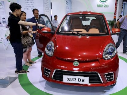 Visitantes ante un coche eléctrico en la feria de Pekín.