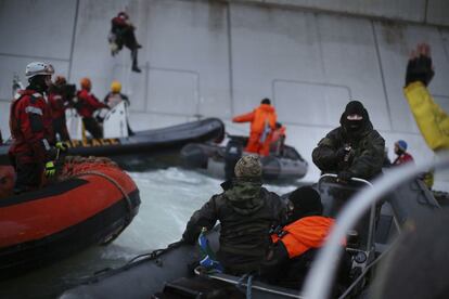 Las fuerzas de seguridad rusas llegaron incluso a apuntar con pistolas a los activistas. Al fonde se ve a un miembro de Greenpeace escalando por la plataforma. El objetivo de los activistas era instalarse sobre la plataforma, que pertenece a una filial de Gazprom, y desplegar en ella una pancarta advirtiendo de los peligros de la extracción de crudo en el Ártico.