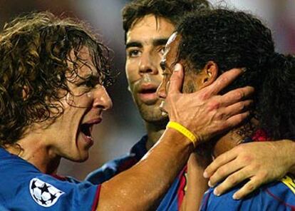 Puyol y Oleguer felicitan a Ronaldinho tras su gol.