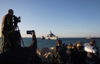 Curiosos y medios de comunicación observan la llegada del buque de la Marina italiana al puerto de Shengjin (Albania), este miércoles.