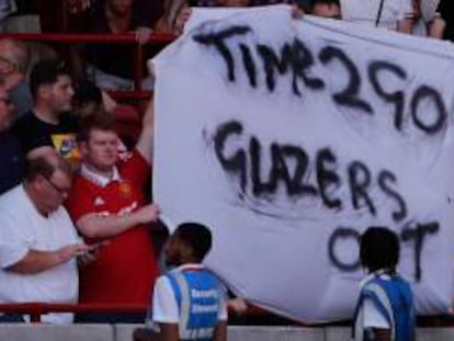 Un aficionado del Manchester United sostiene una pancarta contra la familia Glazer. AFP