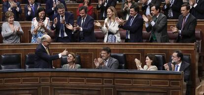 Cristóbal Montoro recibe las felicitaciones de la bancada del PP al termino de la votación.