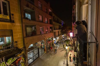 Jordi Gordon, portavoz de SOS Malasaña, y Andrés Martínez, un vecino, contemplan desde un balcón el bullicio un sábado reciente en la calle Velarde.