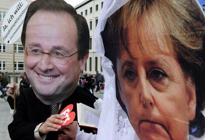 Activistas con máscaras de François Hollande y Angela Merkel fingen un matrimonio en Berlín.