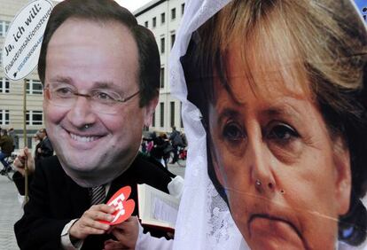 Activistas con m&aacute;scaras de Fran&ccedil;ois Hollande y Angela Merkel fingen un matrimonio en Berl&iacute;n.