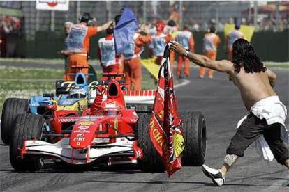 Un espectador entusiasta de Ferrari irrumpe en la pista para felicitar a Michael Schumacher.