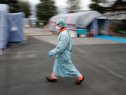 Un trabajador sanitario camina entre las instalaciones de emergencia instaladas en Brescia, al norte de Italia.