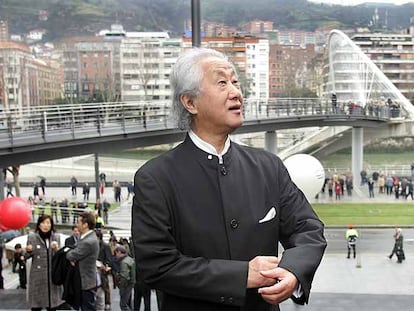 El arquitecto japonés Arata Isozaki, delante del paso elevado que diseñó para conectar la pasarela de Calatrava (al fondo) a Uribitarte en Bilbao, en 2019.