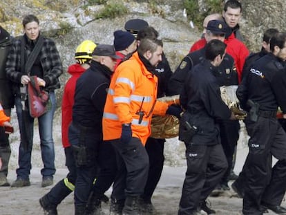 Miembros de los equipos de rescate trasladan el cadáver de uno de los policías.
