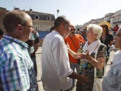 El diputado general de Gipuzkoa, Martín Garitano (centro), y el alcalde de San Sebatián, Juan Carlos Izaguirre (izquierda), saludan a representantes de la asociación de familiares de presos de ETA Etxerat invitados al inicio de las fiestas de Vitoria.