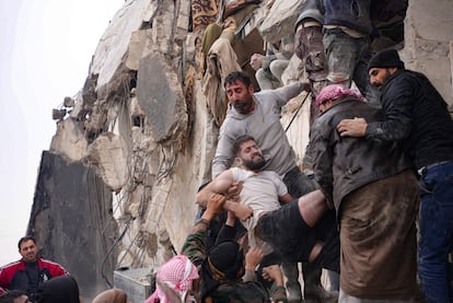  Residents retrieve an injured man from the rubble of a collapsed building following an earthquake in the town of Jandaris, in the countryside of Syria's northwestern city of Afrin in the rebel-held part of Aleppo province.