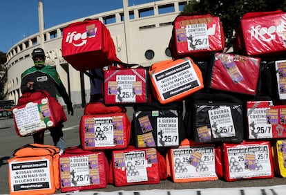 Motoboy ao lado de mochilas de entregas em frente ao estádio do Pacaembu, em São Paulo. durante segundo breque dos apps.