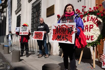 Manifestantes a las afueras del Palacio de La Moneda sostienen pancartas con frases de condena a la dictadura y en memoria de las víctimas. 