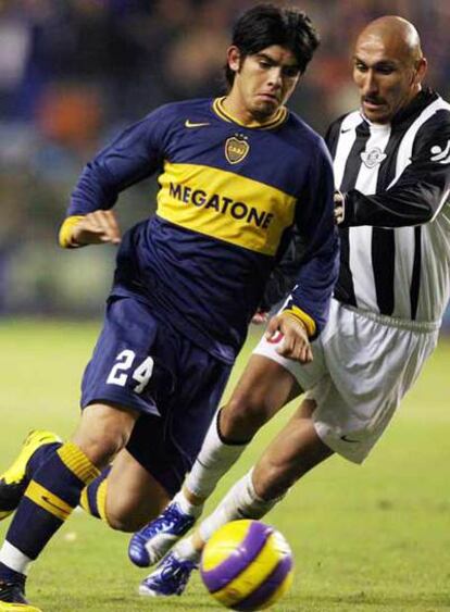 Banega se escapa de Guiñazú en un partido con Boca Juniors.