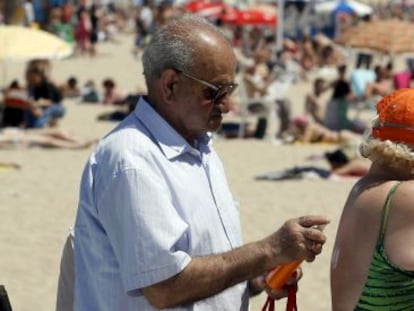 Una pareja de jubilados se dirige a la playa de El Postiguet, en Alicante